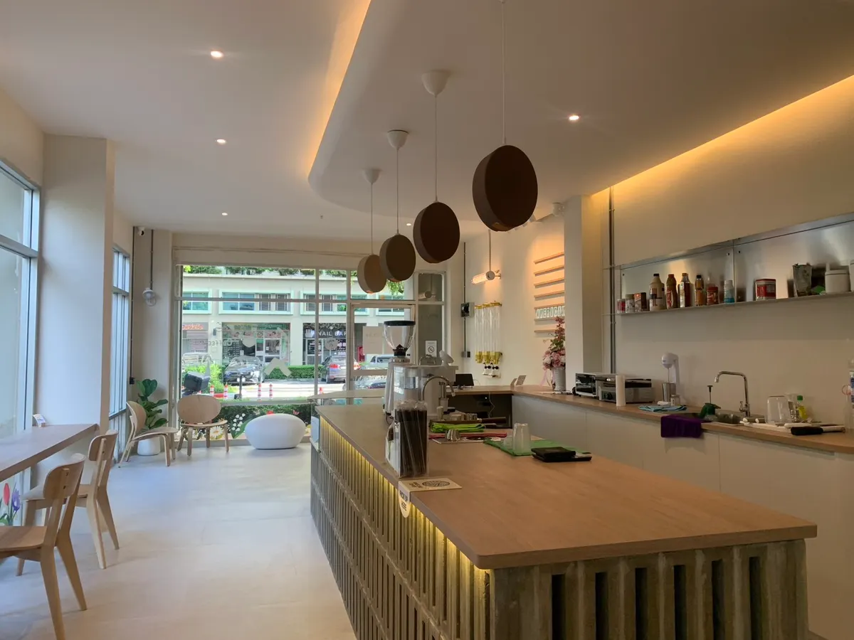 เคาน์เตอร์ไม้และโคมรูปเมล็ดกาแฟภายในร้าน ROASTLINE รามอินทรา